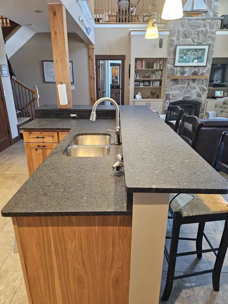 Raised Black Pearl leathered granite bar top over a kitchen island in a New Hampshire home