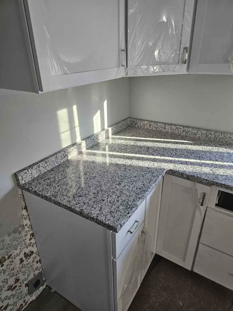 Granite countertops with natural movement installed in a white kitchen in NH