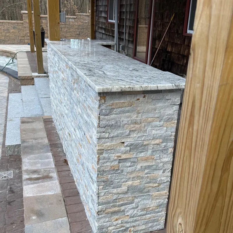 Granite bar top on a stone patio base in a New Hampshire backyard.