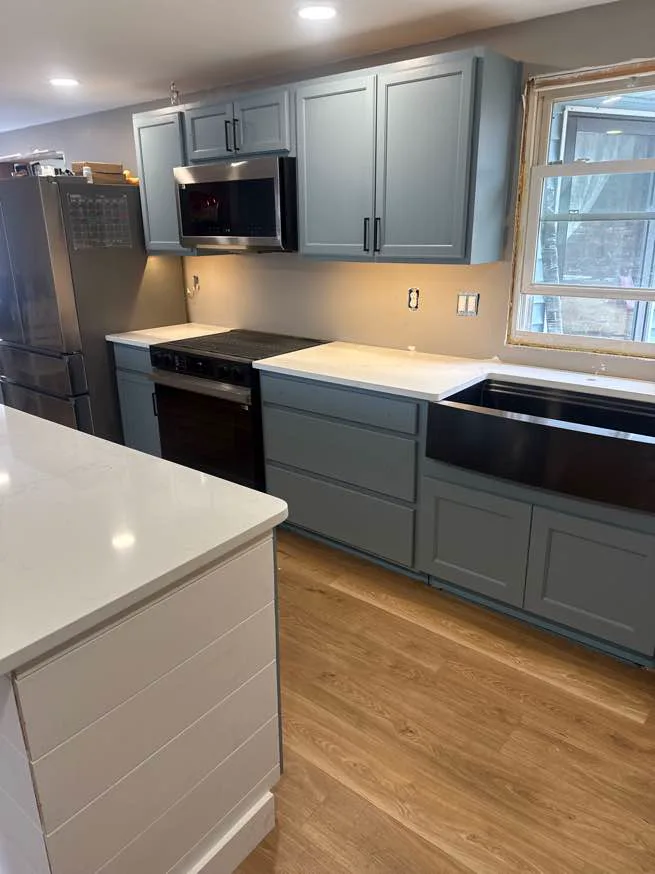 White quartz countertops with farmhouse sink in a finished NH kitchen remodel