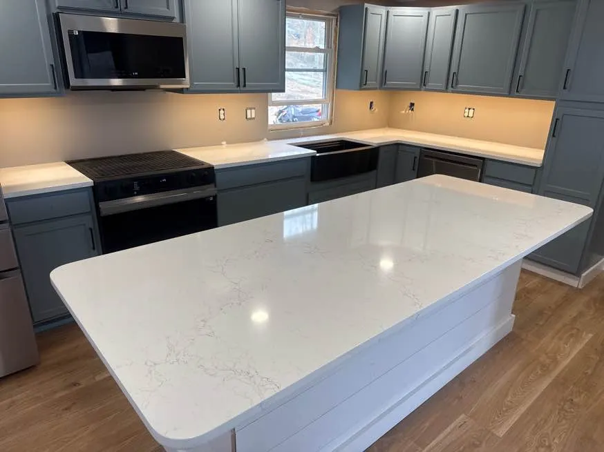 Myora quartz kitchen island with subtle veining paired with slate-blue cabinetry in a New Hampshire home
